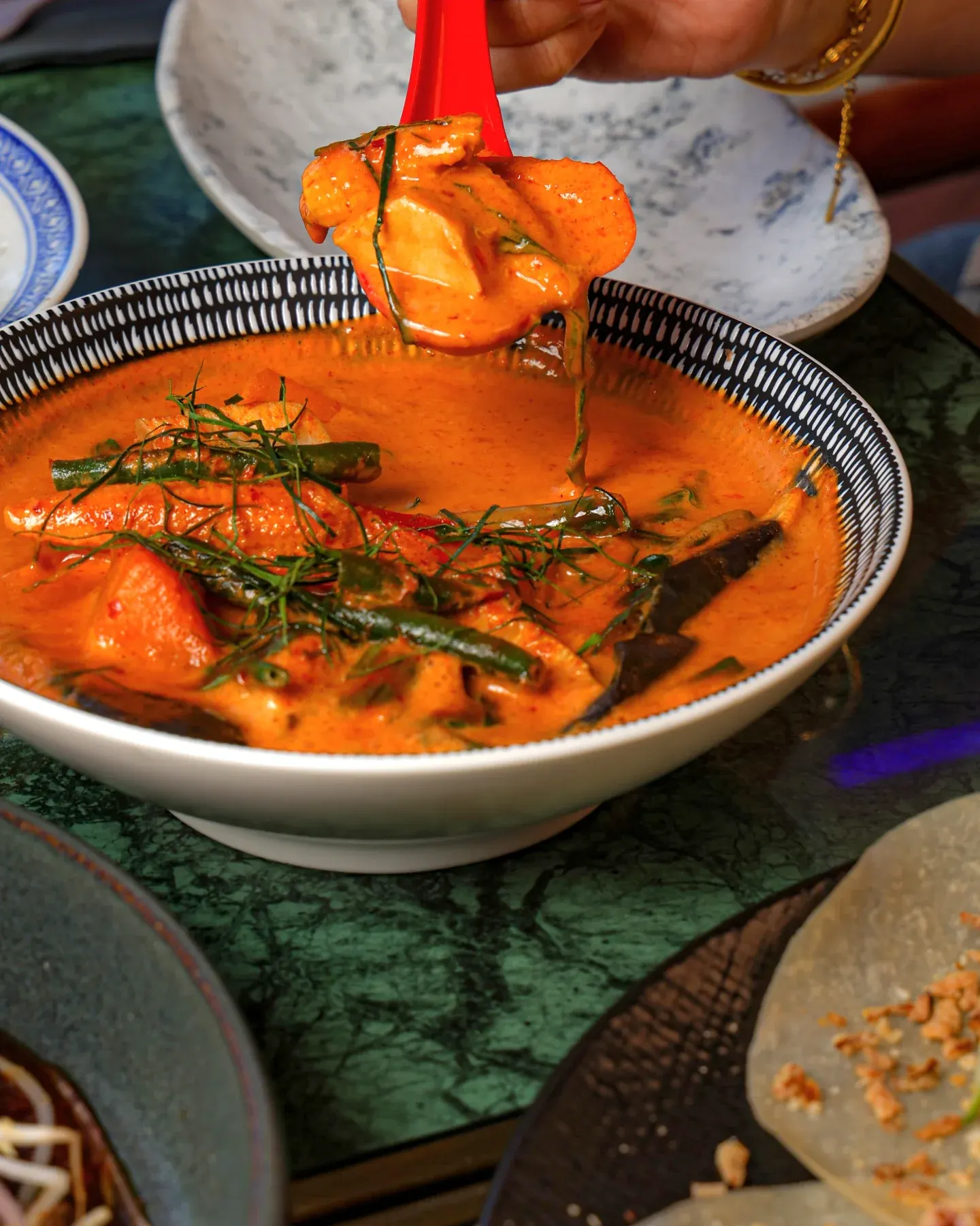 Red curry being ladled